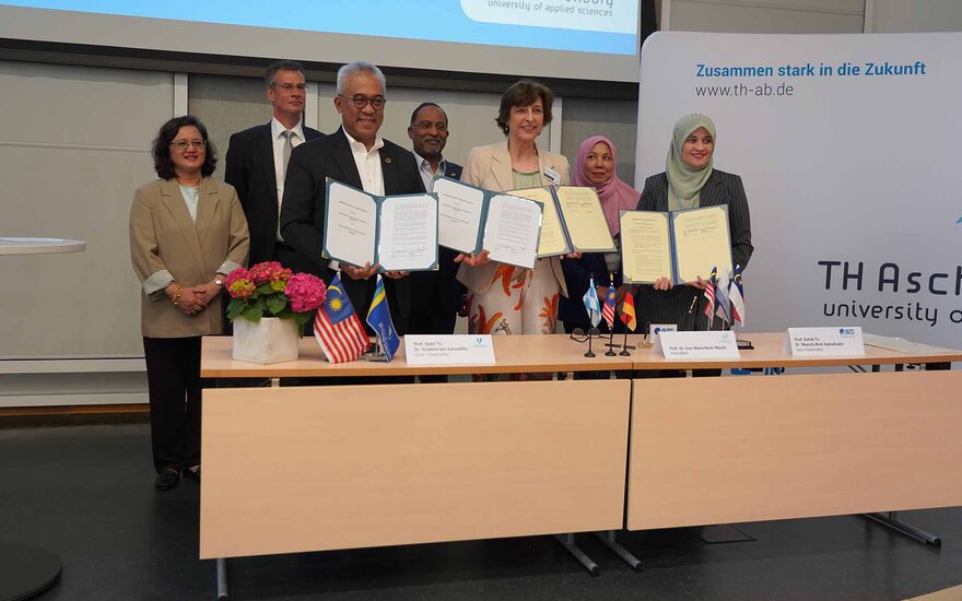 Gruppenfoto in der Aula mit Prof. Dr. Eva-Maria Beck-Meuth bei der Delegation Malaysia.