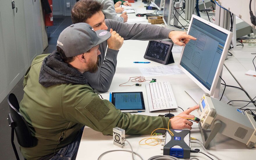  Studierende arbeiten mit Kraftsensor, Funktionsgenerator und Universal-Messelektronik.