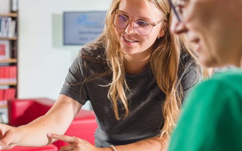 Zwei Frauen an Service-Theke der Bibliothek