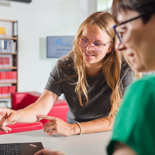 Zwei Frauen an Service-Theke der Bibliothek