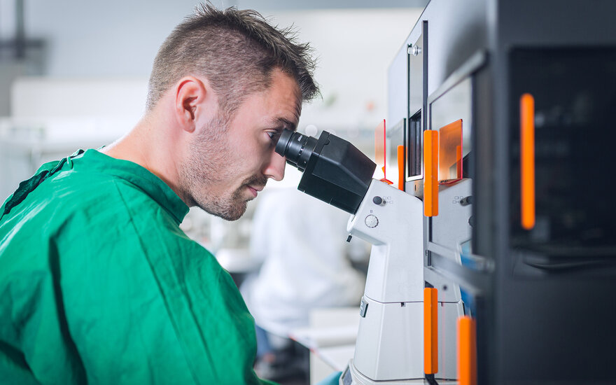 Ein Schüler schaut durch das Mikroskop im BioMems Lab der TH Aschaffenburg.