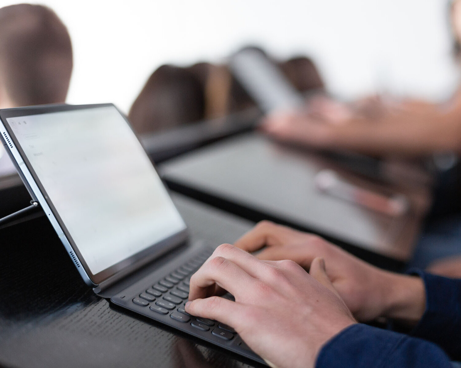 Close up of tablet with keyboard in classroom with students