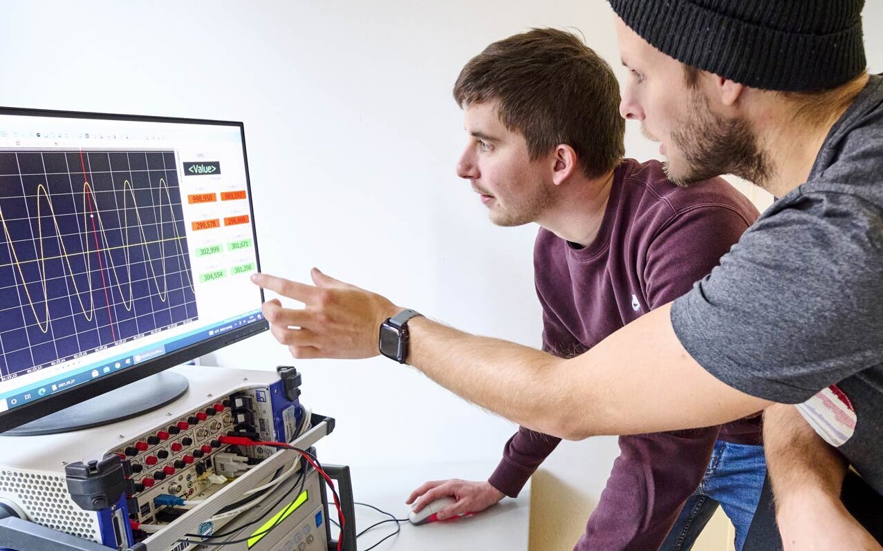 Zwei Doktoranden im Labor für Elektrische Maschinen, Leistungselektronik und Antriebe.