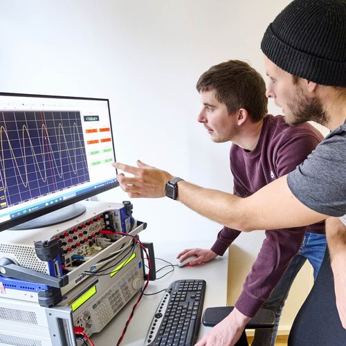 Zwei Doktoranden im Labor für Elektrische Maschinen, Leistungselektronik und Antriebe.