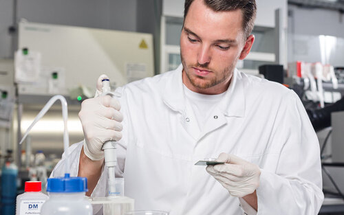 Ein Labormitarbeiter des BioMEMS Lab nimmt Flüssigkeit mit einer Pipette auf. 