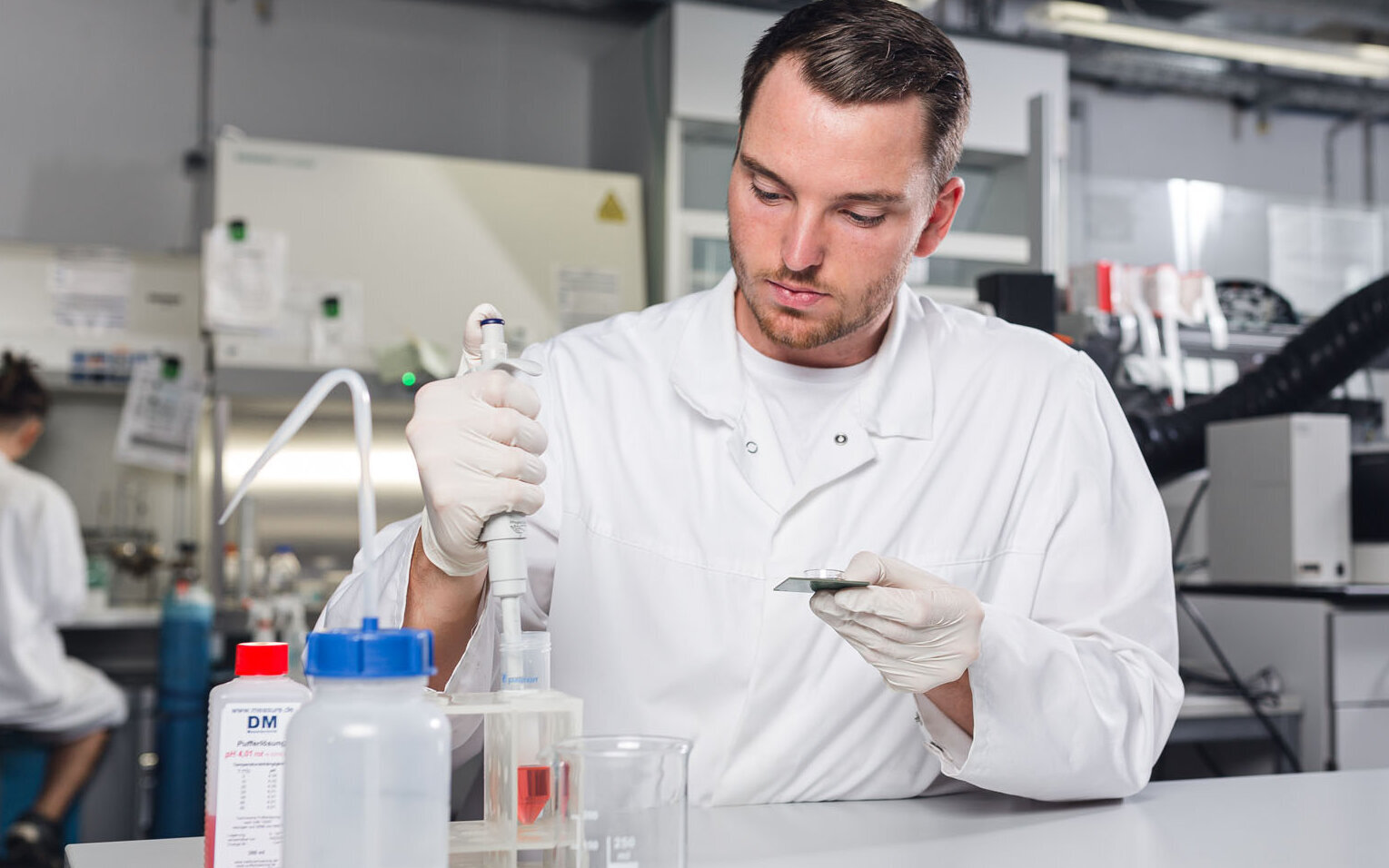 Ein Labormitarbeiter des BioMEMS Lab nimmt Flüssigkeit mit einer Pipette auf. 