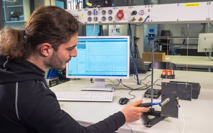 Ein Student im Labor für Dynamik und Schwingungstechnik während eines Versuchs.