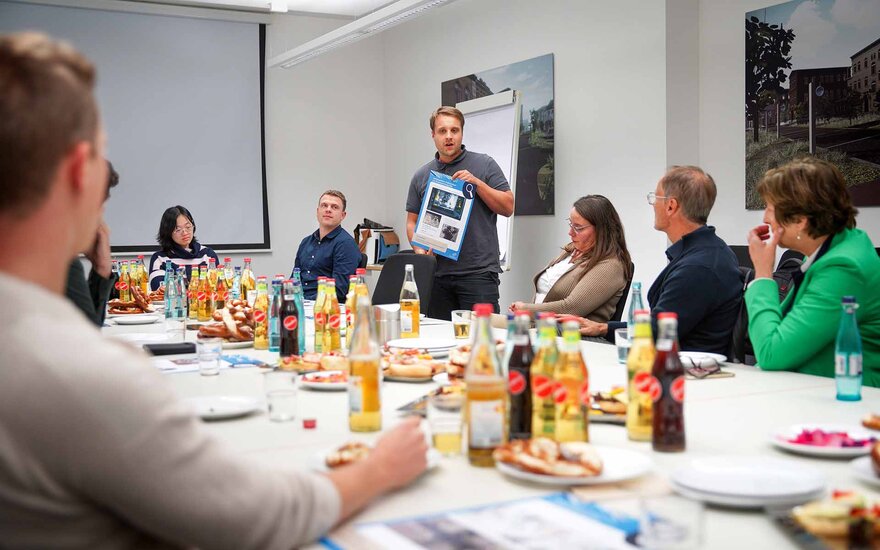 Doktorand Dominik Mücke präsentiert ein Poster mit den Inhalten seiner Promotion.