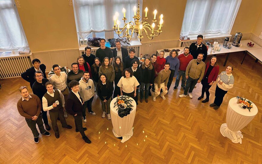 Gruppenfoto mit allen Teilnehmenden im Hocksaal vom Balkon aufgenommen