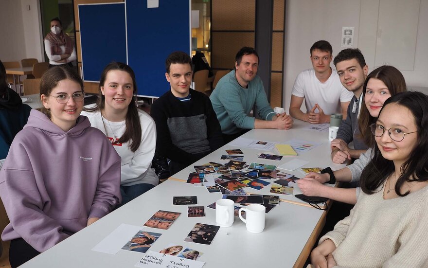 Studierende sitzen gemeinsam am Tisch.