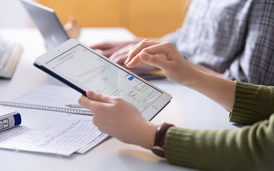 Tablet in der Hand einer SD-Studentin in Detailansicht