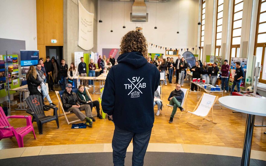  Eine Studentenvertreterin spricht von der Bühne in der Aula aus zu den Anwesenden.