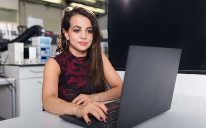 Eine Promovendin sitzt am Laptop und arbeitet im BioMEMS Lab der TH Aschaffenburg.