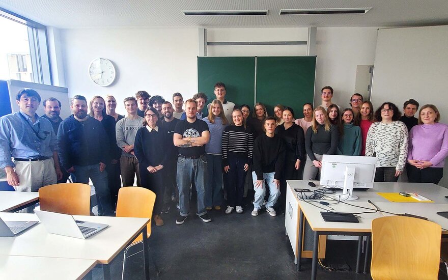 Gruppenfoto im Hörsaal vor der Tafel