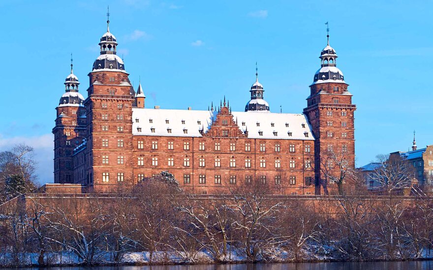 Aschaffenburger Schloss mit schneebedecktem Dach vor blauem Himmel