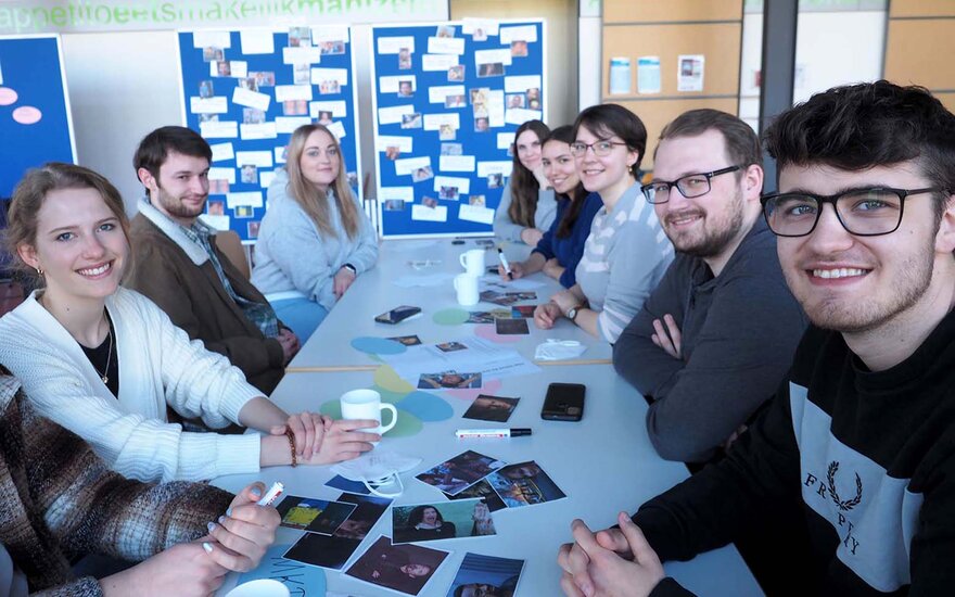 Studierende sitzen gemeinsam am Tisch.