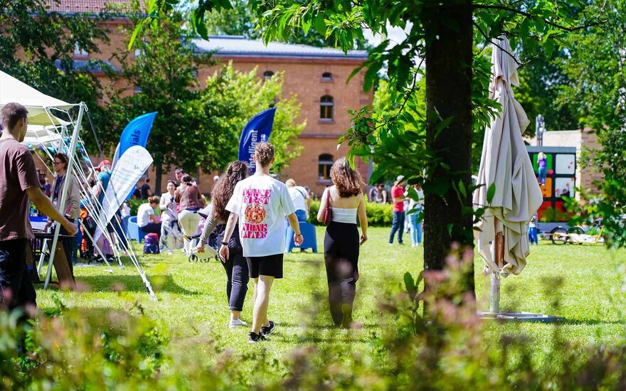 Drei Mitglieder der Studentenvertretung laufen gemeinsam über den Open Campus.