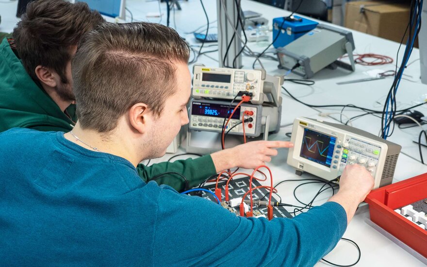 Studierende während einer Messung mit einem Oszilloskop.