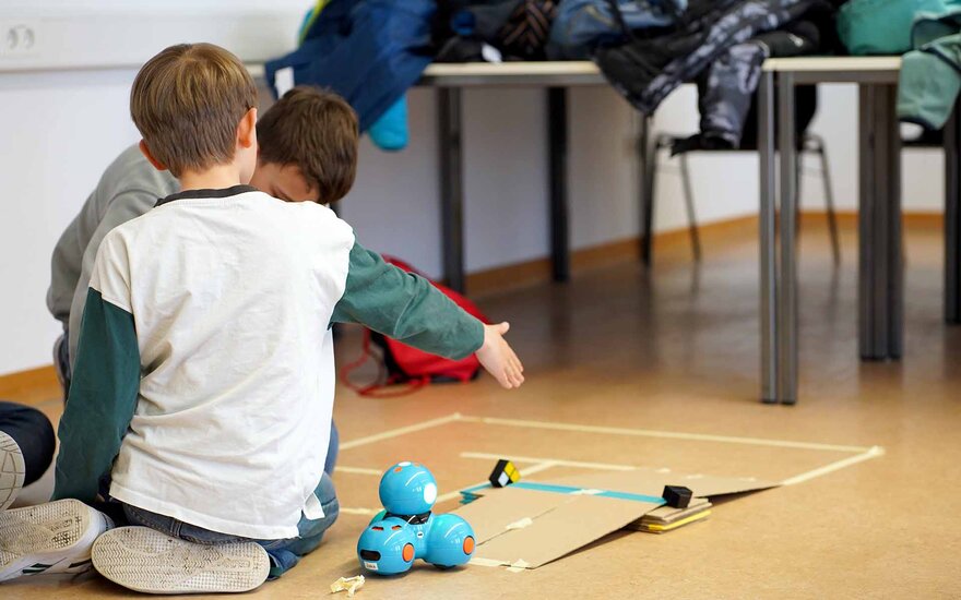 Zwei Kinder spielen auf dem Boden.