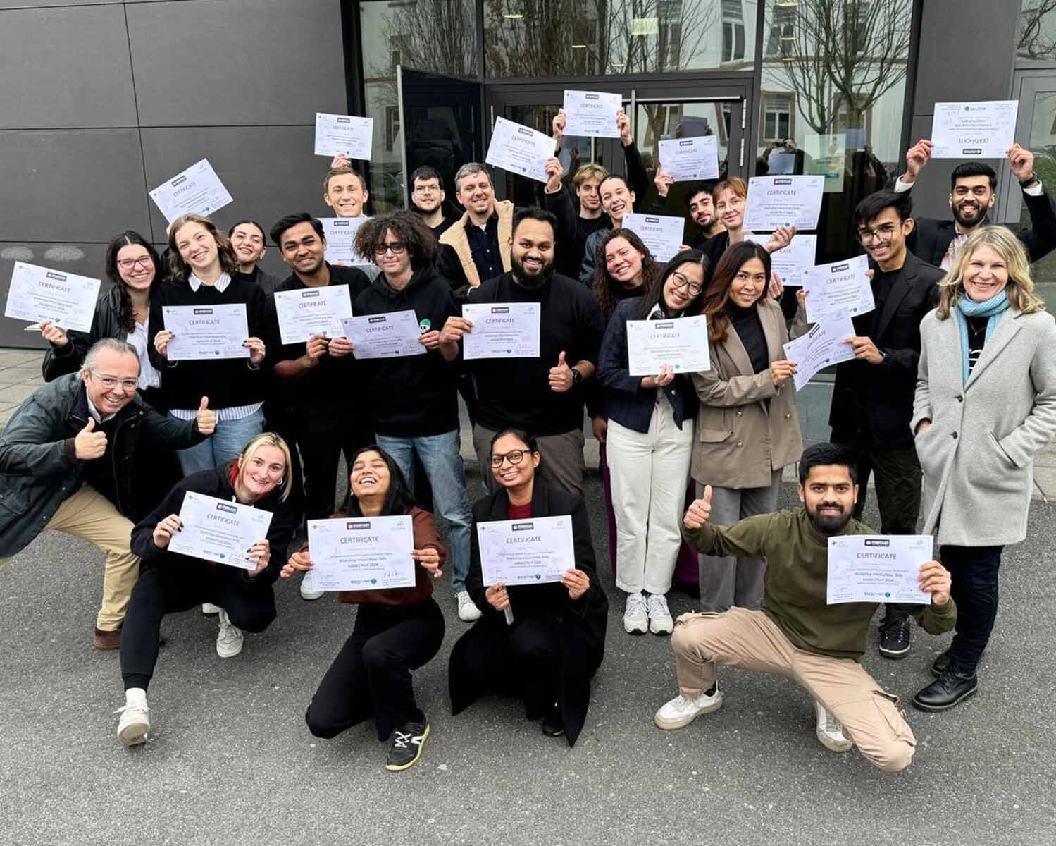 Gruppenfoto der Mercuri-Studierenden auf dem Campus mit Zertifikaten in der Hand