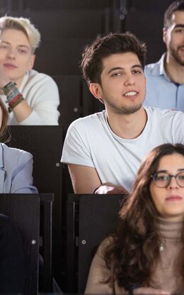 Mehrere Studierende in einem Hörsaal während einer Vorlesung in Frontalansicht