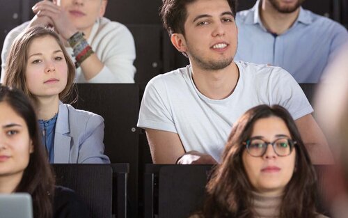 Mehrere Studierende in einem Hörsaal während einer Vorlesung in Frontalansicht