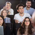 Mehrere Studierende in einem Hörsaal während einer Vorlesung in Frontalansicht