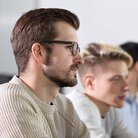 Mehrere Studierende in einer Sitzreihe während einer Vorlesung in einem Hörssal im Gebäude 40