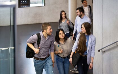 Studierende laufen zur nächsten Vorlesung im Gebäude 40 und unterhalten sich