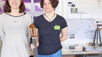 Anna und Susanne stehen nebeneinander und halten eine Gitarre in den Händen