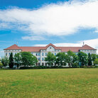 Campus-Wiese und Gebäude 20 am Campus 1 Hochschulgebäude der Technischen Hochschule Aschaffenburg, umgeben von Grünanlagen an einem sonnigen Tag.