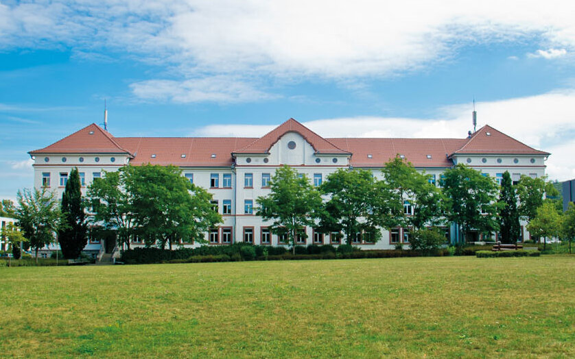 Campus-Wiese und Gebäude 20 am Campus 1 Hochschulgebäude der Technischen Hochschule Aschaffenburg, umgeben von Grünanlagen an einem sonnigen Tag.