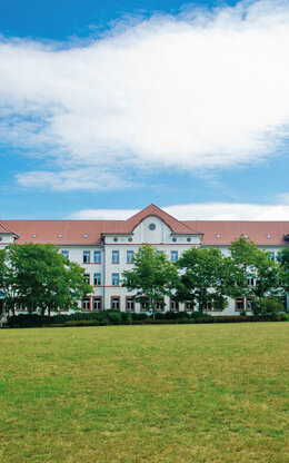 Campus-Wiese und Gebäude 20 am Campus 1 Hochschulgebäude der Technischen Hochschule Aschaffenburg, umgeben von Grünanlagen an einem sonnigen Tag.