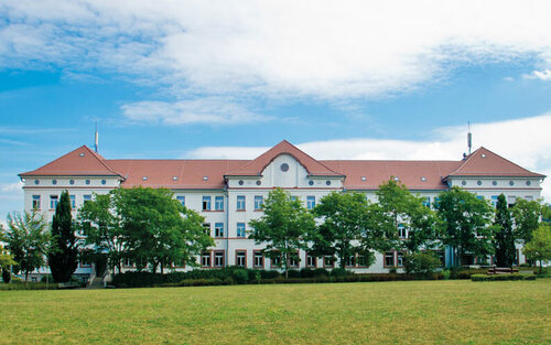 Campus-Wiese und Gebäude 20 am Campus 1 Hochschulgebäude der Technischen Hochschule Aschaffenburg, umgeben von Grünanlagen an einem sonnigen Tag.