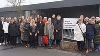 Gruppenfoto der Teilnehmenden vor dem Schild und Container der Fakultät Gesundheitswissenschaften.