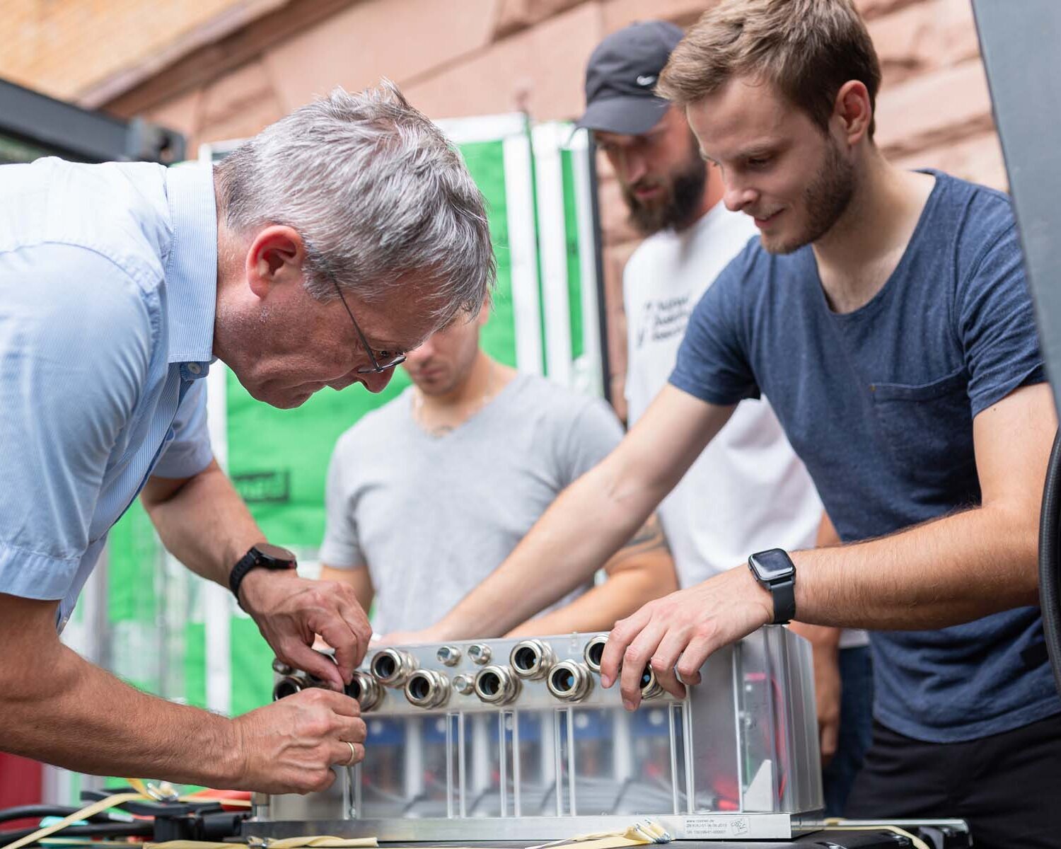 Studierende der Fakultät Ingenieurswissenschaften arbeiten zusammen mit einem Dozenten an einem Versuchsaufbau.