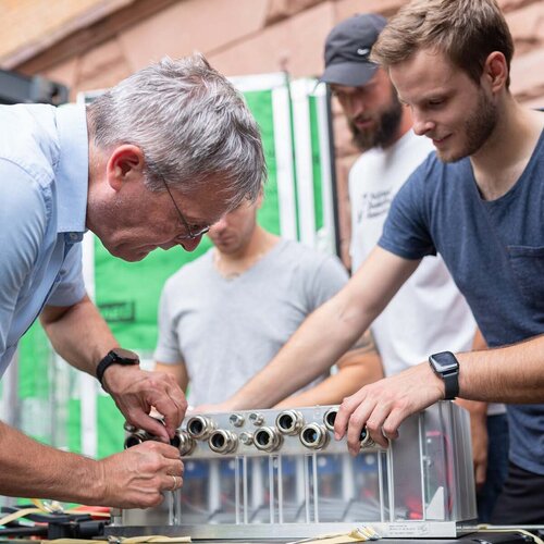 Studierende der Fakultät Ingenieurswissenschaften arbeiten zusammen mit einem Dozenten an einem Versuchsaufbau.