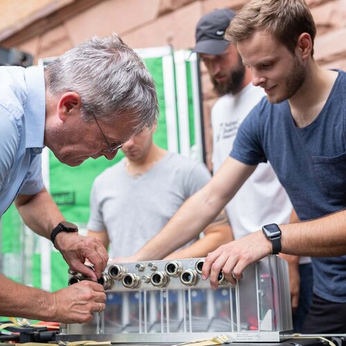 Studierende der Fakultät Ingenieurswissenschaften arbeiten zusammen mit einem Dozenten an einem Versuchsaufbau.