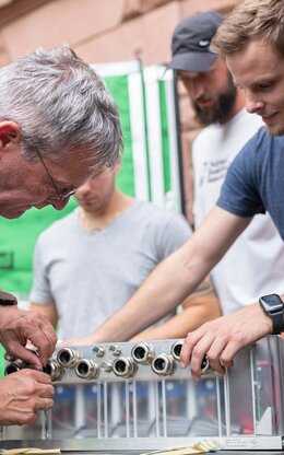 Studierende der Fakultät Ingenieurswissenschaften arbeiten zusammen mit einem Dozenten an einem Versuchsaufbau.