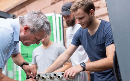 Studierende der Fakultät Ingenieurswissenschaften arbeiten zusammen mit einem Dozenten an einem Versuchsaufbau.