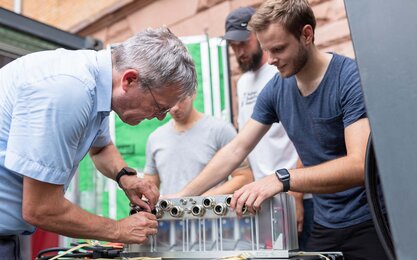 Studierende der Fakultät Ingenieurswissenschaften arbeiten zusammen mit einem Dozenten an einem Versuchsaufbau.