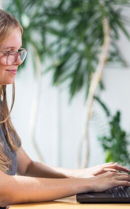 Studentin mit Laptop in der Bibliothek