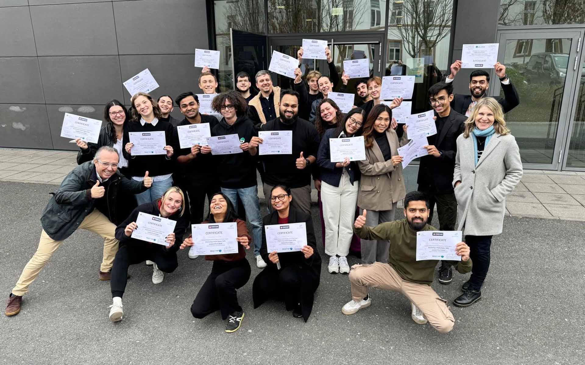 Gruppenfoto der Mercuri-Studierenden auf dem Campus mit Zertifikaten in der Hand